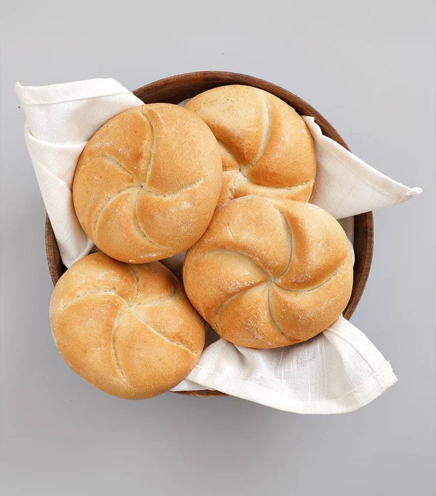 Basket of bread with cloth placed on a neutral gray background.