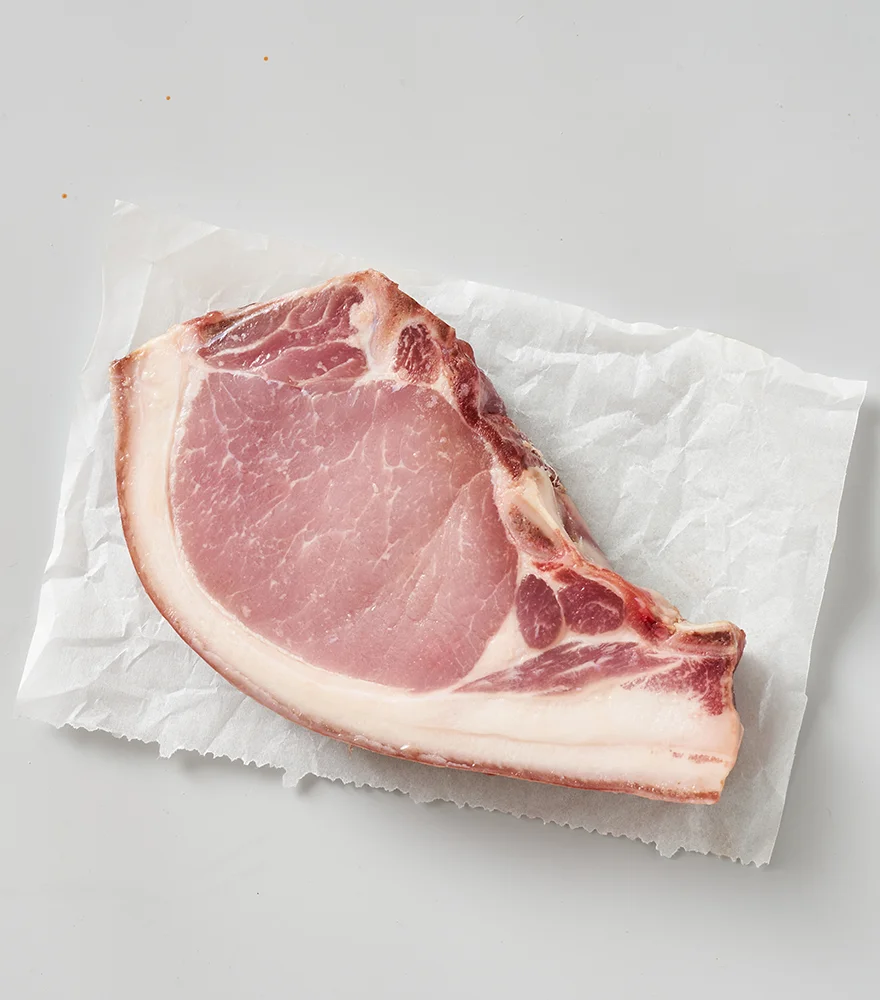 Original image of raw meat on parchment with muted colors and gray shadows.