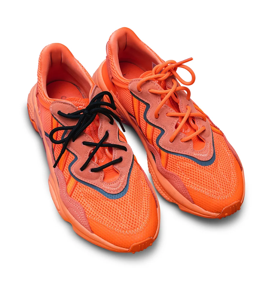 Same orange sneakers on a white background with adjusted shadows.