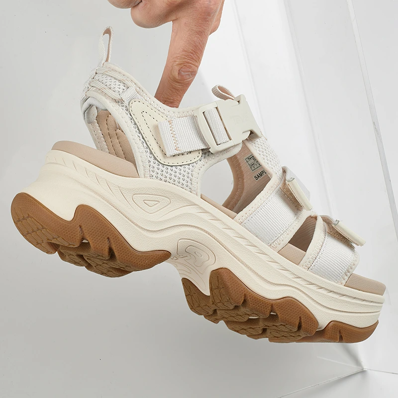 Original image of a sandal being held by hand on reflective background.