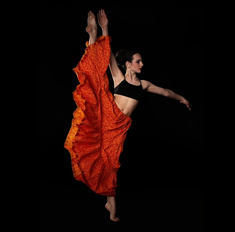 Dancer portrait with dark background and vibrant costume after correction.