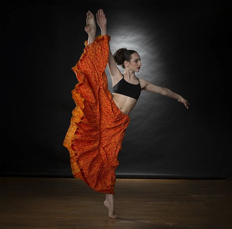 Studio dance photo with poor lighting and faded costume colors.