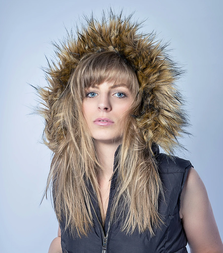 Natural image of a woman in a fur-lined jacket before background removal.