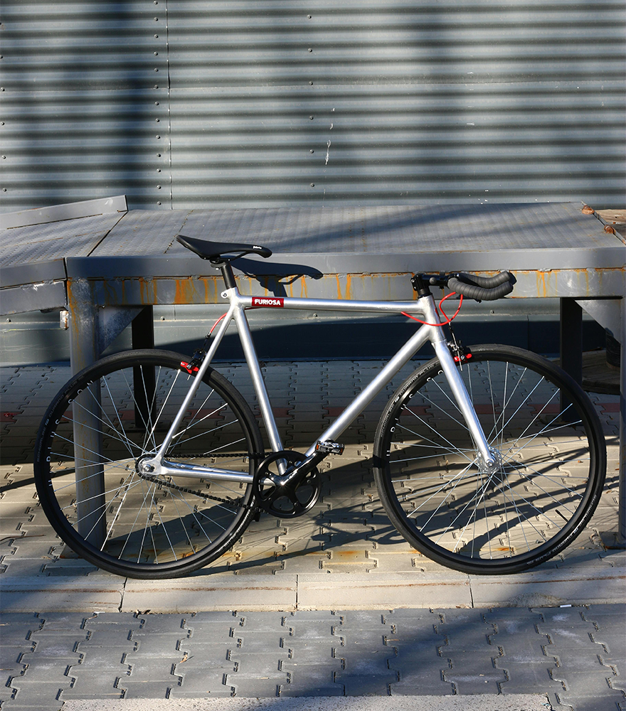 Full bike photo with detailed background including shadows and metal textures.