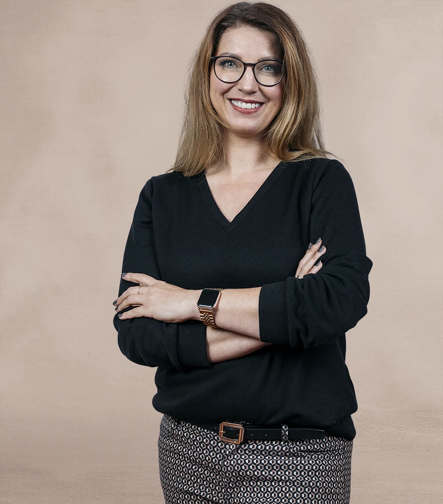 Portrait of a woman inside a busy warehouse setting with distracting background elements.