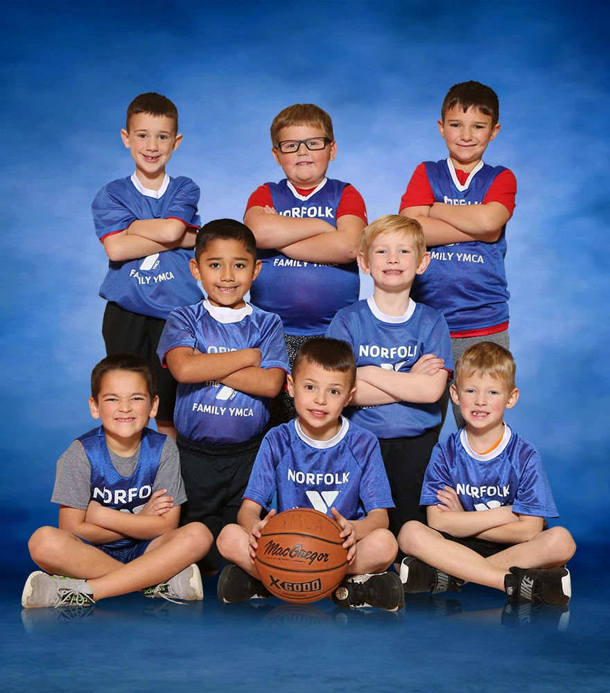 Youth basketball team portrait with a clean blue gradient background.
