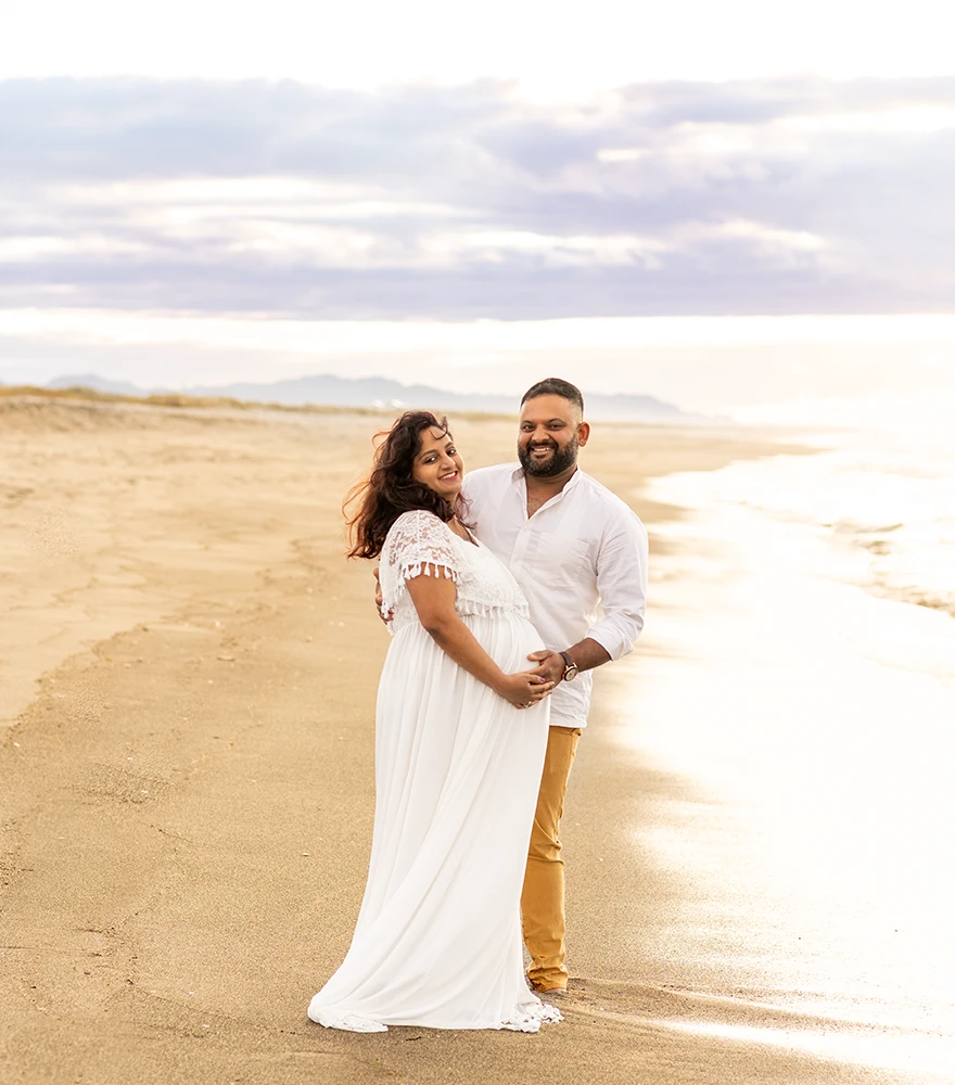 Original maternity photo on a beach with natural lighting.