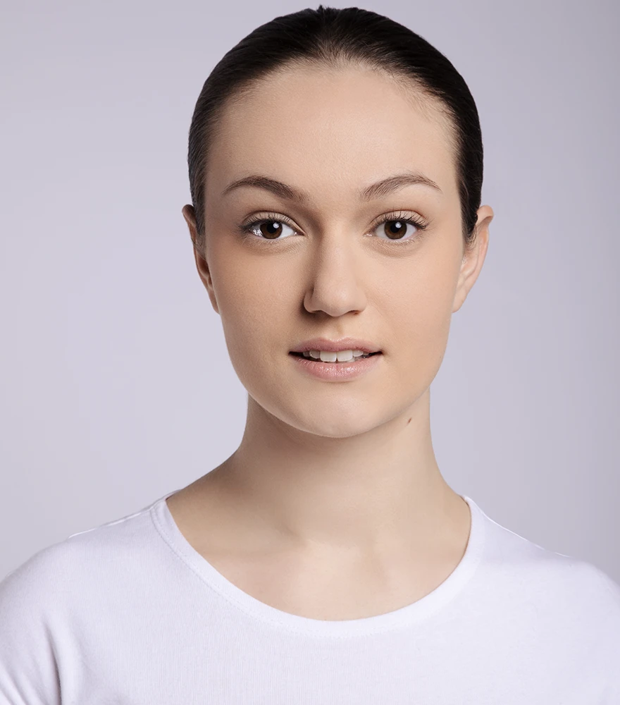 A softly retouched portrait of a woman with even skin tone and natural finish.