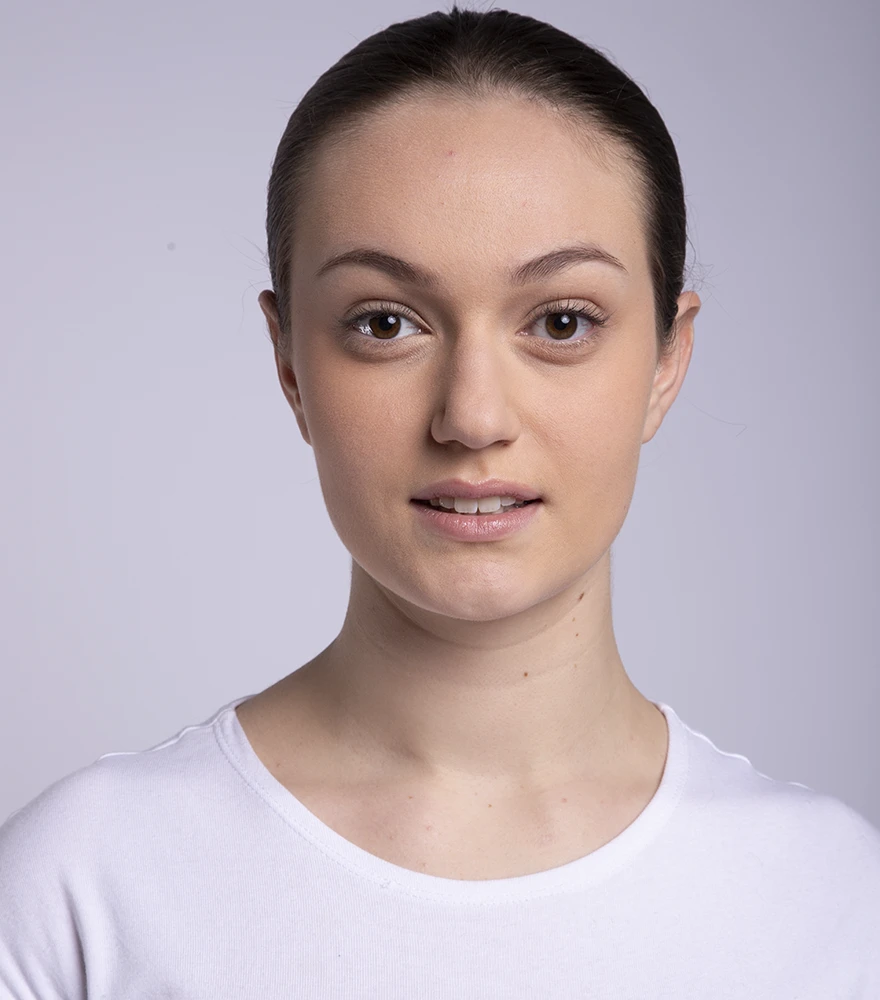 Unedited photo of a woman showing minor skin texture and lighting issues.