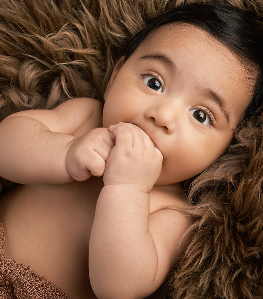 Professional retouch of a baby photo with smooth skin and vivid tones.