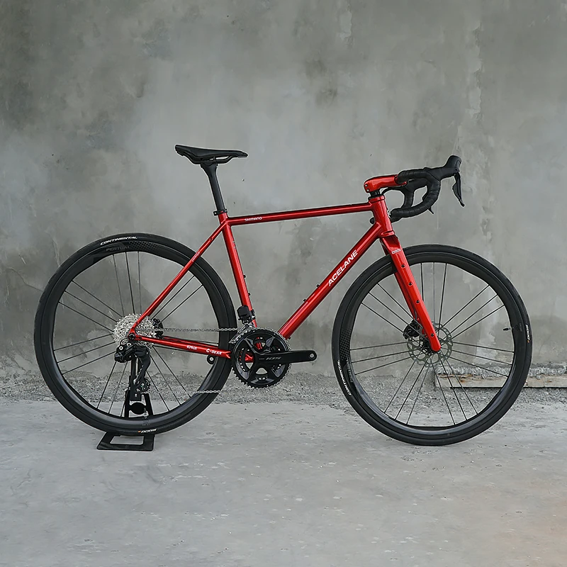 Red sports bicycle shot against a concrete wall before editing.