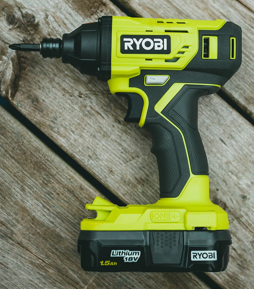 Color & Texture Enhancement_Before Original product photo of a power drill placed on a wooden background with natural lighting.