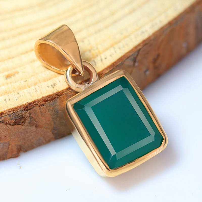 Original photo of green gemstone pendant placed on wooden surface.