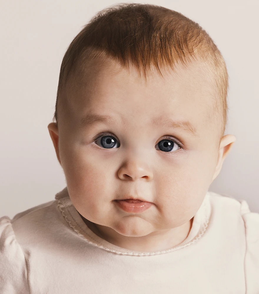 Baby portrait with enhanced lighting and warm color tones.