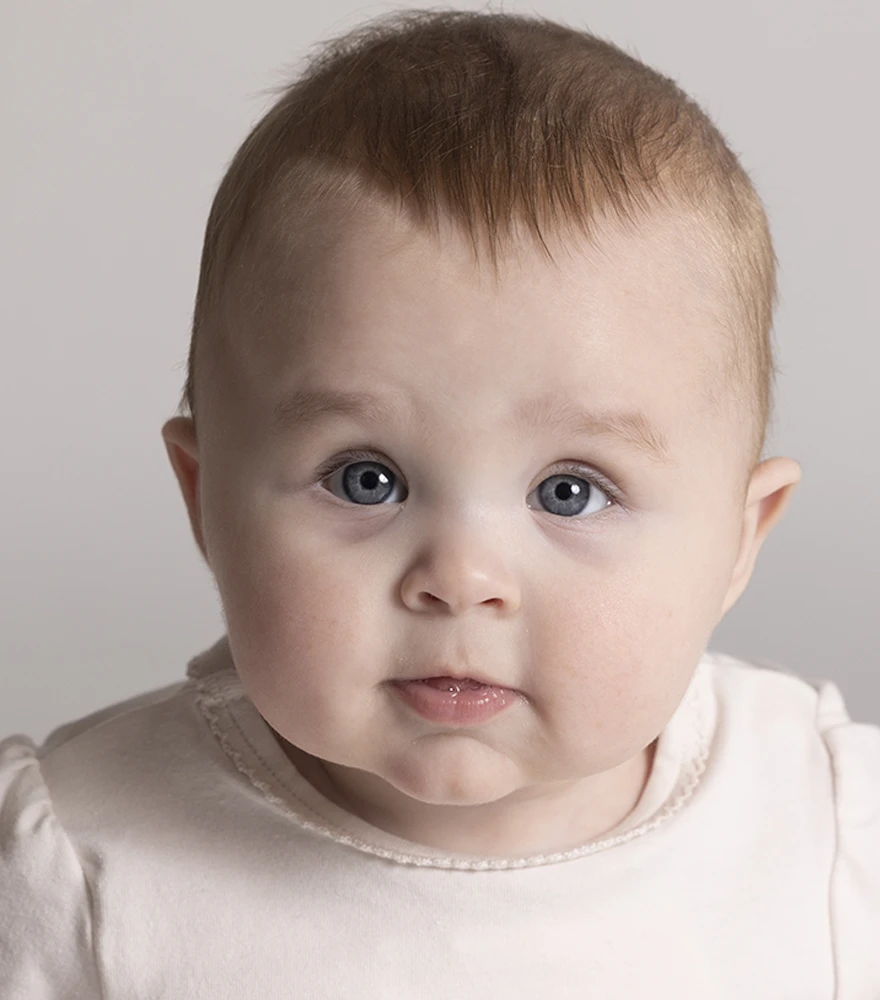 Baby portrait with pale lighting and muted tones before enhancement.