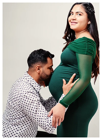Maternity photo of a couple embracing the baby bump with loving expressions.