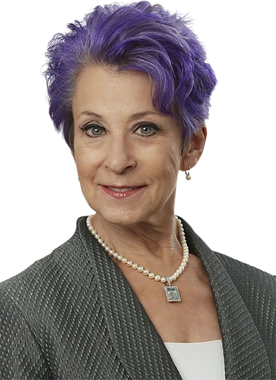 Retouched senior fashion model with vibrant purple hair and elegant attire.