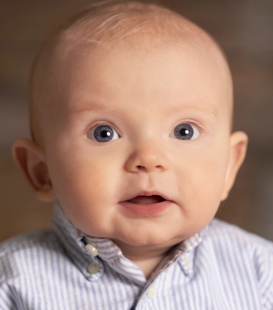 Close-up of a baby with softened skin, brightened eyes, and enhanced lighting.