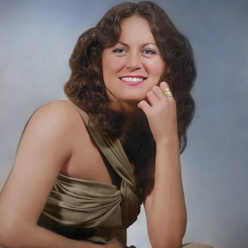 Restored portrait of a woman in a green dress with vibrant colors, clear skin tones, and clean background.