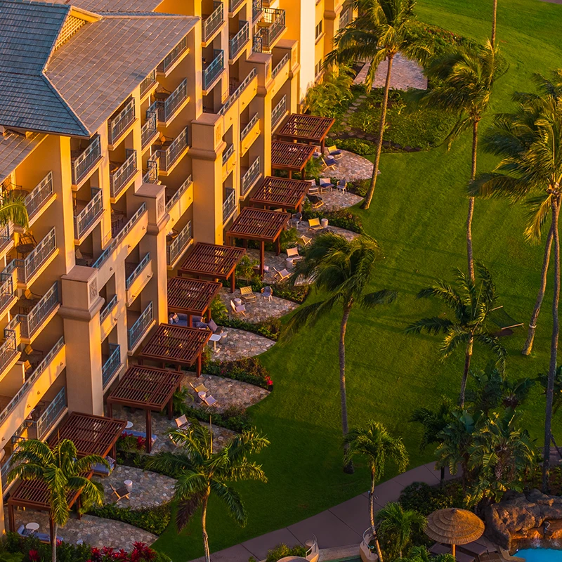 Aerial view of resort with vibrant lighting, greenery, and enhanced symmetry.