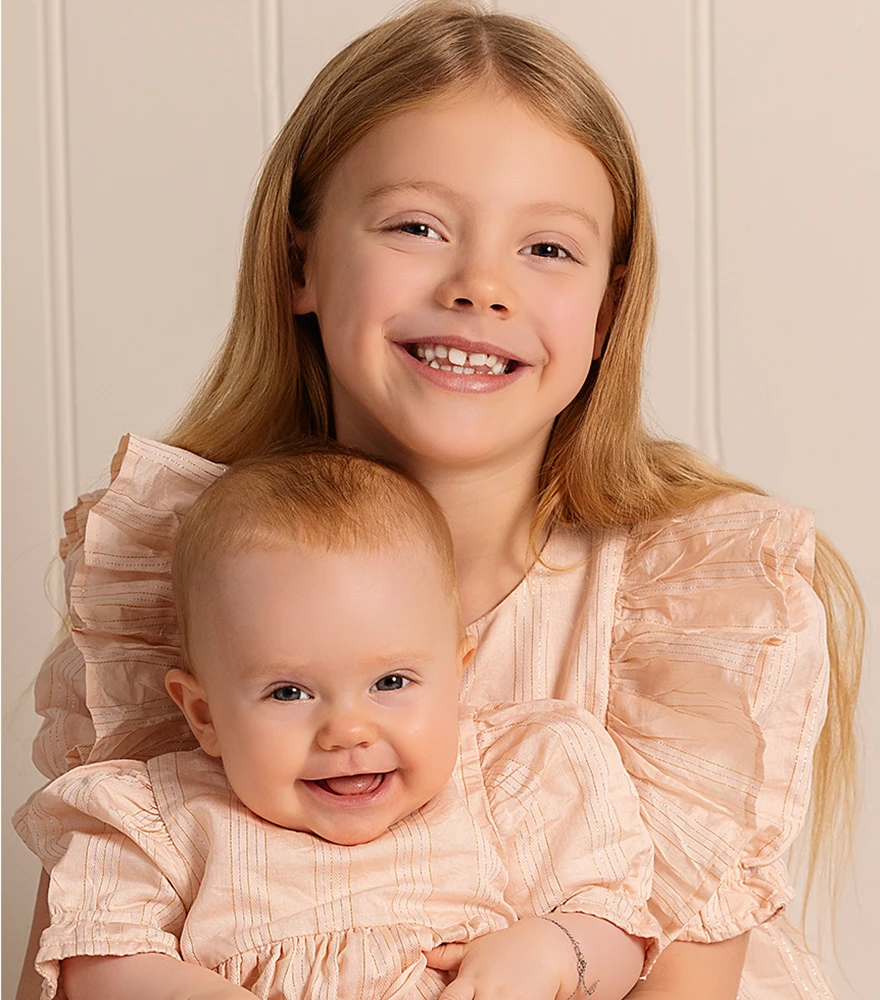 Retouched sibling portrait with smooth skin and corrected tones.