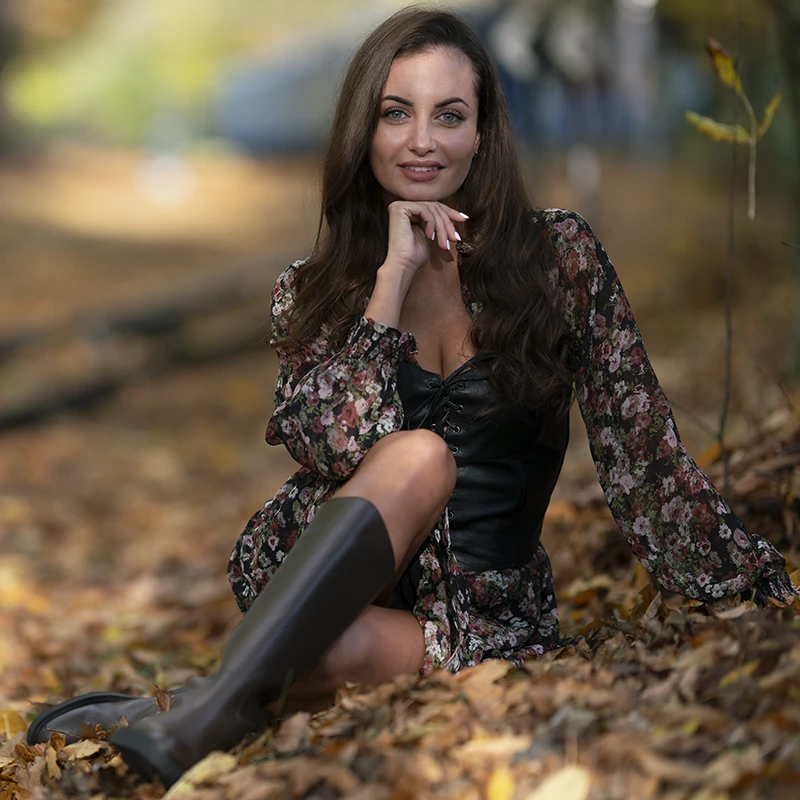 Portrait of a woman in an autumn setting with dark exposure and low contrast.