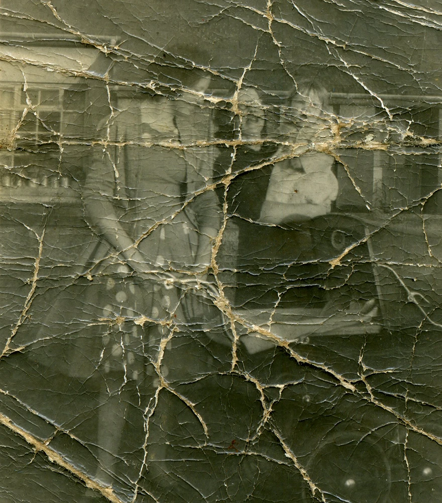 Tear & Damage Repair_Before Heavily damaged old photo of two women and a child with severe cracks, tears, and fading.