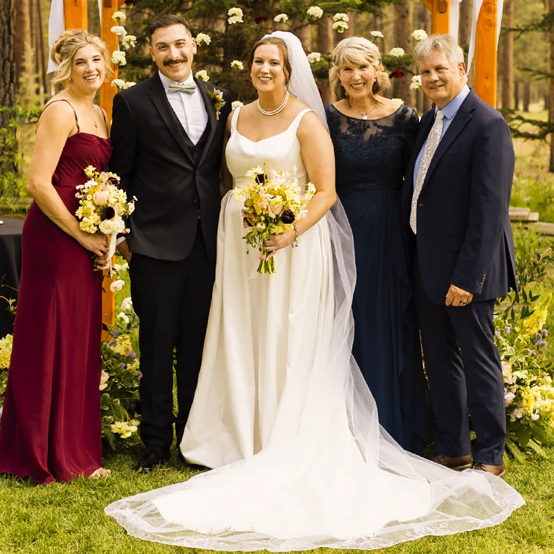 Retouched sunset photo of bride and family with heightened warmth and contrast.
