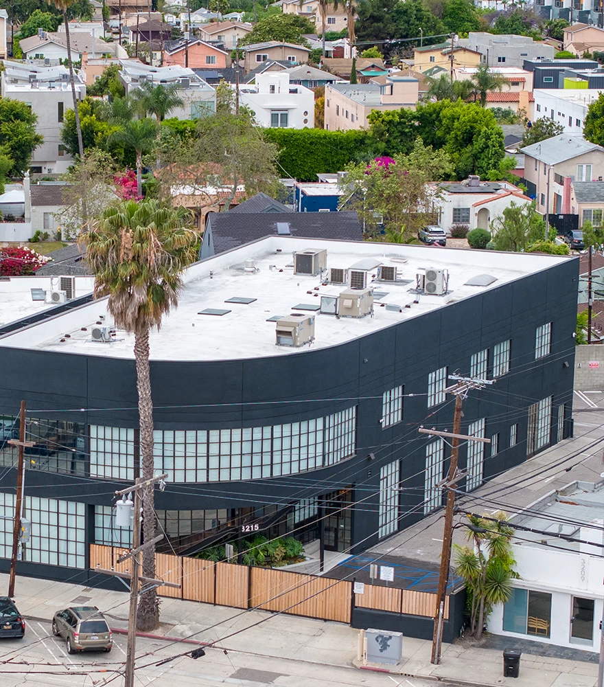Commercial building with multiple overhead power lines and utility poles in front.