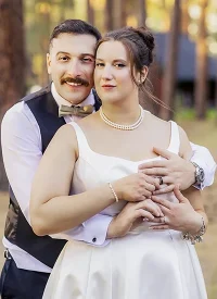 Groom embracing bride in a professionally retouched wedding portrait.